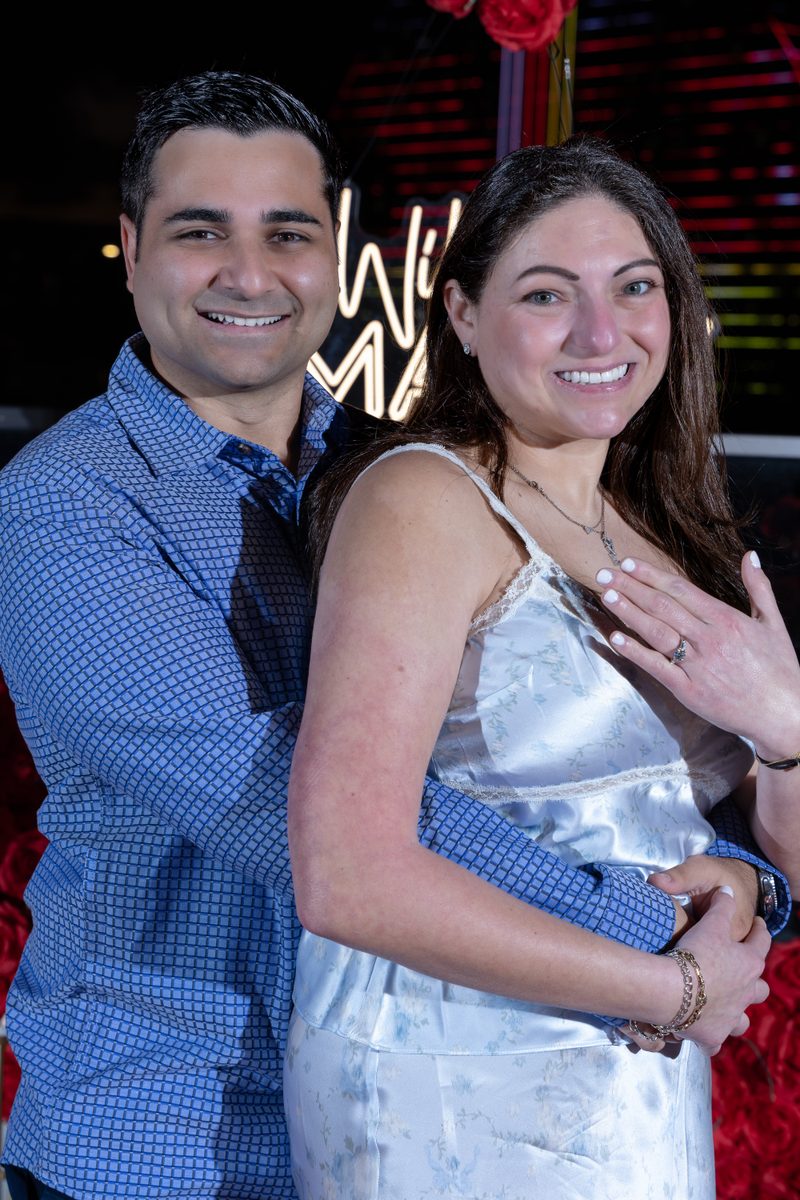 Couple smiling together showing engagement ring